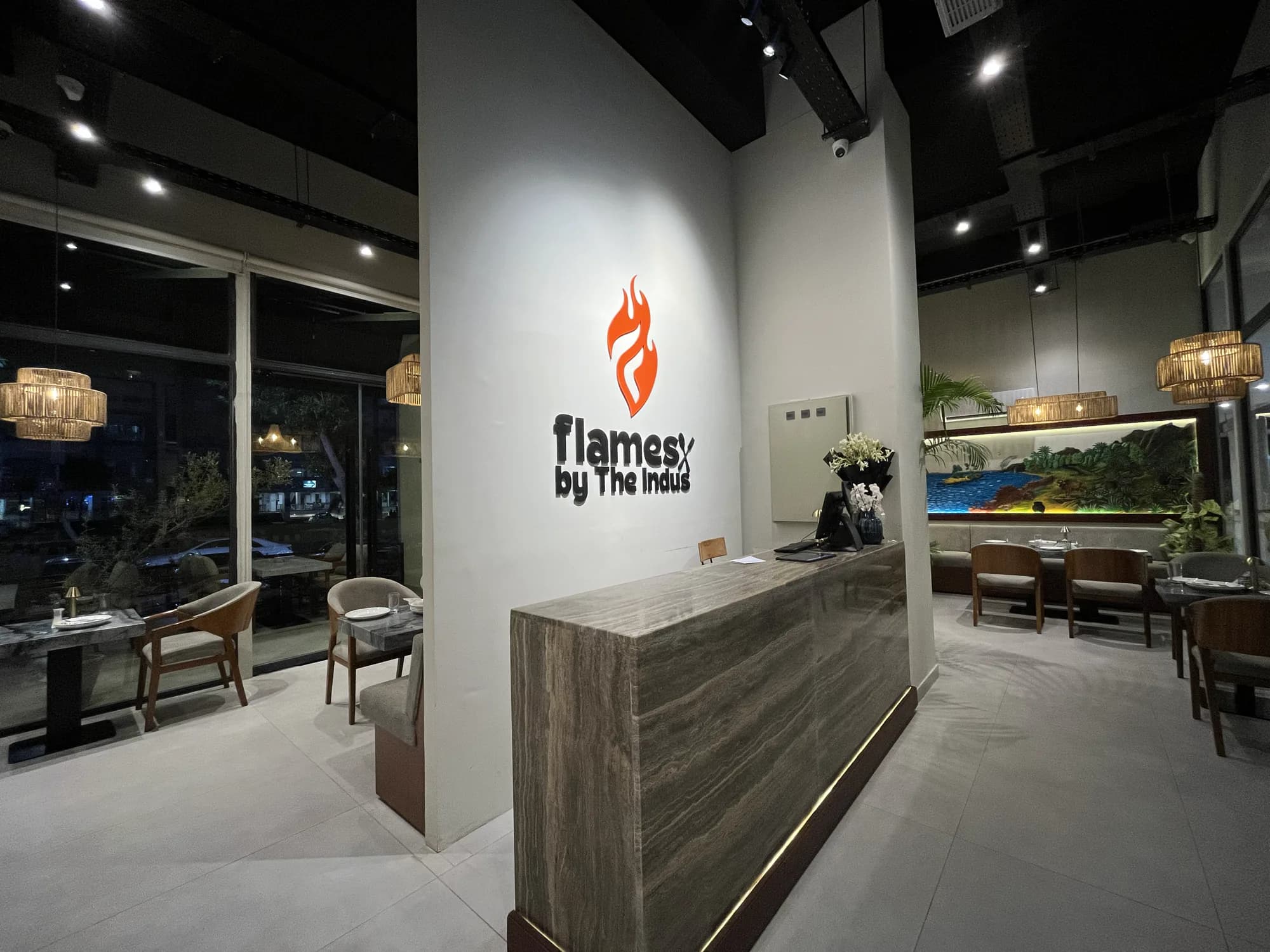 The reception desk at Flames by the Indus, the flame mark on the wall behind it
